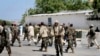 FILE - Somali soldiers patrol at the front gate of the presidential palace following a suicide bomb attack in Mogadishu, Jan. 29, 2013. 