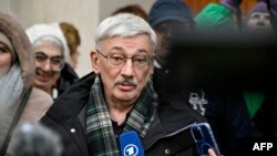 Oleg Orlov, the 70-year-old human rights campaigner and co-chair of the Nobel Prize winning Memorial group, who is charged with 'discrediting' the Russian army, talks to the media and his supporters outside a court building in Moscow, Feb. 26, 2024. 