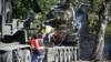 FILE - Workers remove a Soviet T-34 tank installed as a monument in Narva, Estonia, Aug. 16, 2022. Russia's invasion of Ukraine has led to a renewed push to topple the last remaining monuments to the Soviet army that remained in Europe. 