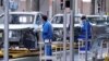 FILE - Employees work on assembly line during a construction completion event of SAIC Volkswagen MEB electric vehicle plant in Shanghai, China, Nov. 8, 2019.