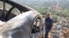 FILE - A Palestinian man checks a car burned in a raid by Israeli settlers near Salfit in the Israeli-occupied West Bank, Dec. 3, 2023.