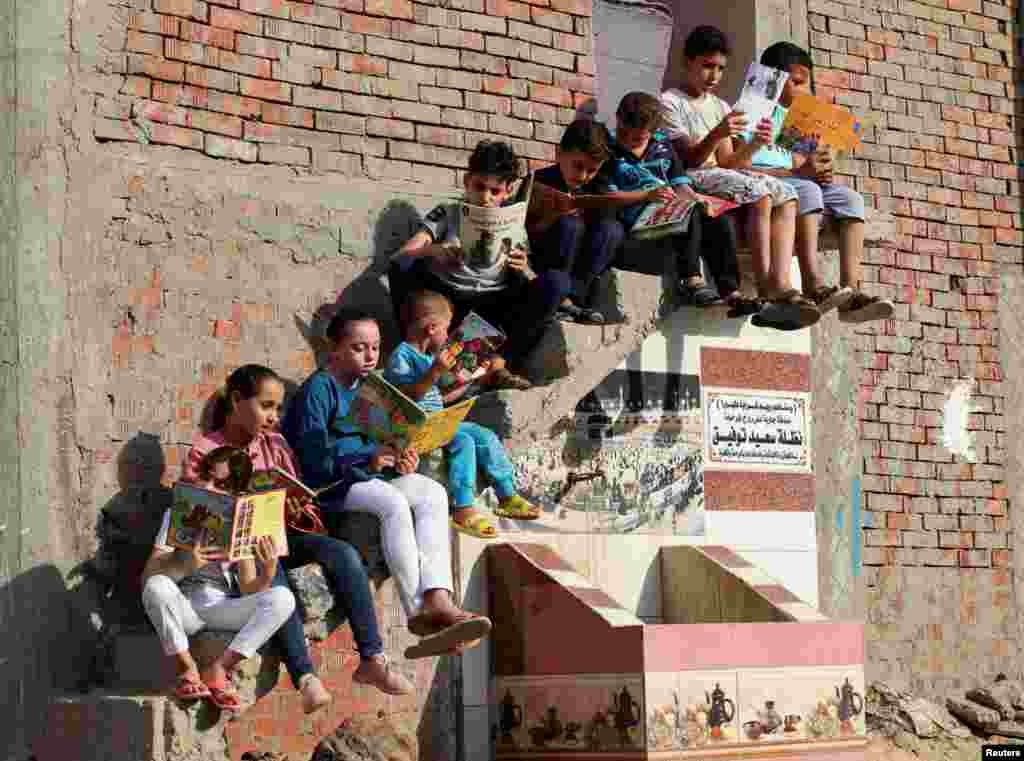 Children read books they borrowed from&nbsp;Mohamed Abdel Aziz&#39;s house, which has been turned into a free learning center for village students lacking access to cultural services and activities,&nbsp;at Bishet Amer village in the Sharqia Governorate, north of Cairo, Egypt.