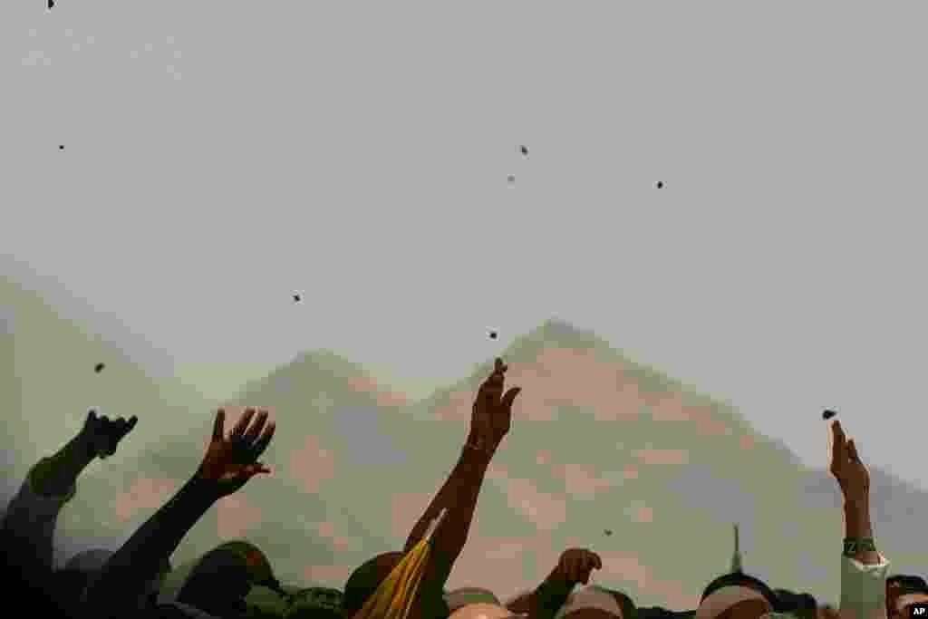 Muslim pilgrims cast stones at pillars in the symbolic stoning of the devil, the last rite of the annual Hajj, in Mina near the holy city of Mecca, Saudi Arabia.