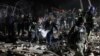 Ukrainian police officers and rescuers carry the body of a local resident killed in a Russian rocket attack in Kramatorsk, Donetsk region, on Feb. 17, 2024.