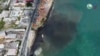 This video grab taken from a handout footage released on Feb. 10, 2024 by the Tobago House Assembly shows emergency workers scramble to clean up a massive oil spill after a mysterious vessel ran aground near the Caribbean island earlier this week in Trinidad and Tobago. 