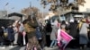 FILE - A member of Taliban forces fires in the air to disperse the Afghan women during a rally to protest against what the protesters say is Taliban restrictions on women, in Kabul, Dec. 28, 2021. 