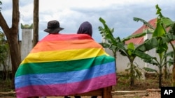 Wapenzi wawii wa jinsia moja nchini Uganda wakijifunika na bendera ya kujivunia ushoga, Machi 25, 2023. Picha ya AP