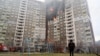 A law enforcement officer stands next to a residential building, damaged as a result of a missile attack in Kyiv, Ukraine, on Feb. 7, 2024.