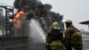Ukrainian emergency personnel douse water to extinguish flames after a fire erupted at the site of a drone attack in Kharkiv, Feb. 10, 2024. Seven people, including three children, were killed in a Russian drone attack on the city of Kharkiv. 