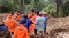 This handout photo released on April 14, 2024 by the National Search and Rescue Agency (BASARNAS) shows rescuers carrying a body bag at a landslide site in Tana Toraja, South Sulawesi. 