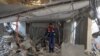 A Palestinian worker walks amid debris at a water desalination plant that was hit during a strike in Nuseirat in the central Gaza Strip on June 7, 2024.
