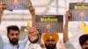 Supporters of the Aam Admi Party leader and Delhi Chief Minister Arvind Kejriwal hold posters at a protest organized by INDIA bloc, a group formed by opposition parties, in New Delhi, India, March 31, 2024. 