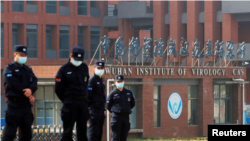Sejumlah petugas keamanan bersiaga di luar Institut Virologi Wuhan saat kunjungan tim Organisasi Kesehatan Dunia (WHO) untuk meneliti asal mula COVID-19, di Wuhan, Provinsi Hubei, China, 3 Februari 2021. (Foto: Thomas Peter/Reuters)