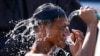 A man douses himself with water along a street as hot temperatures continue in Manila, Philippines, April 26, 2024.