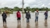 FILE - Residents inspect a road heavily affected by floods following torrential rains in Kitengela, on May 1, 2024. 