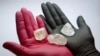 FILE - An employee shows gem-quality stones, including a rare 242-carat rough diamond, to be offered at an auction by Russian state-controlled diamond producer Alrosa, during a presentation in Moscow, Russia, Feb. 25, 2021.