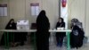 Staff members of a polling station attend to their stations during the parliamentary runoff elections in Tehran, Iran, May 10, 2024. 