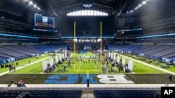 Players and coaches talk with reporters during an NCAA college football news conference at the Big Ten Conference media days at Lucas Oil Stadium, July 24, 2024, in Indianapolis.