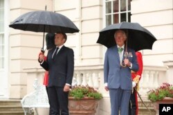 FILE - Britain's Prince Charles welcomes French president Emmanuel Macron, left, to Clarence House in London, Thursday June 18, 2020.