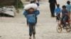FILE - A boy carries food aid given by the U.N.'s World Food Program in Raqqa, Syria, April 26, 2018.