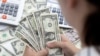 Woman holds U.S. dollar banknotes in this illustration taken May 30, 2022. According to a Prudential Financial survey released, June 24, 2024, women in the U.S. have saved just a third of the amount that men have set aside for retirement.