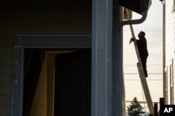 Radnik stoji na merdevinama dok radi na novogradnji u Tigardu, predgrađu Portlanda, Oregon, 22. februara 2024.