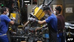 FILE - Technicians work on car assembly lines at the Iran Khodro auto plant, west of the Iranian capital Tehran, Aug. 14, 2022.
