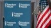 FILE - Freedom House logos are displayed on a panel behind a teleprompter next to a U.S. flag during the rights group's annual awards ceremony in Washington, May 9, 2023.