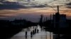 People walk along a flooded street of Eldorado do Sul, Rio Grande do Sul, Brazil, on May 9, 2024. 