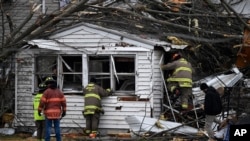 Members of the Huntsville Volunteer Fire Department enter a home to search for victims following a severe storm in Lakeview, Ohio, March 15, 2024. 