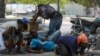 People take cover from gunfire during clashes between police and gangs in the Champs de Mars area next to the National Palace in Port-au-Prince, Haiti, April 8, 2024.