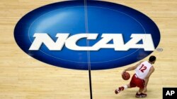 FILE - Wisconsin's Traevon Jackson dribbles past the NCAA logo during practice at the NCAA men's college basketball tournament March 26, 2014, in Anaheim, Calif.