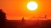 FILE - A migrant walks back to his makeshift camp at sunrise after a failed attempt to cross the Channel to the UK on a small boat, in Sangatte, near Calais, France, Aug. 10, 2023. 