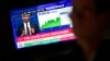 A screen displays news about interest rates as traders work on the floor at the New York Stock Exchange in New York, May 1, 2024. 