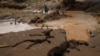 A member of the National Youth Service searches for the bodies of missing people after flash floods wiped out several homes following heavy rains in Kamuchiri village of Mai Mahiu, Nakuru County, Kenya, on May 1, 2024. 