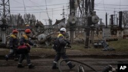 Wafanyakazi wa mitambo ya kuzalisha umeme wakitembea kukarabati uharibifu baada ya shambulio la Russia katikati mwa Ukraine, Januari 5, 2023.