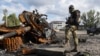 Украинский солдат стоит у подбитого российского танка в Купянске, Харьковской области (архивное фото)