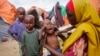FILE - Maryan Madey, who fled the drought-stricken Lower Shabelle region, holds her malnourished daughter Deka Ali, 1, at a camp for the displaced on the outskirts of Mogadishu, Somalia, Sept. 3, 2022. 