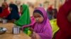 FILE - A child eats at a school in Dollow, Somalia, Sept. 19, 2022. At midday, dozens of hungry children from the camps try to slip into a local primary school where the World Food Program offers a lunch program for students.