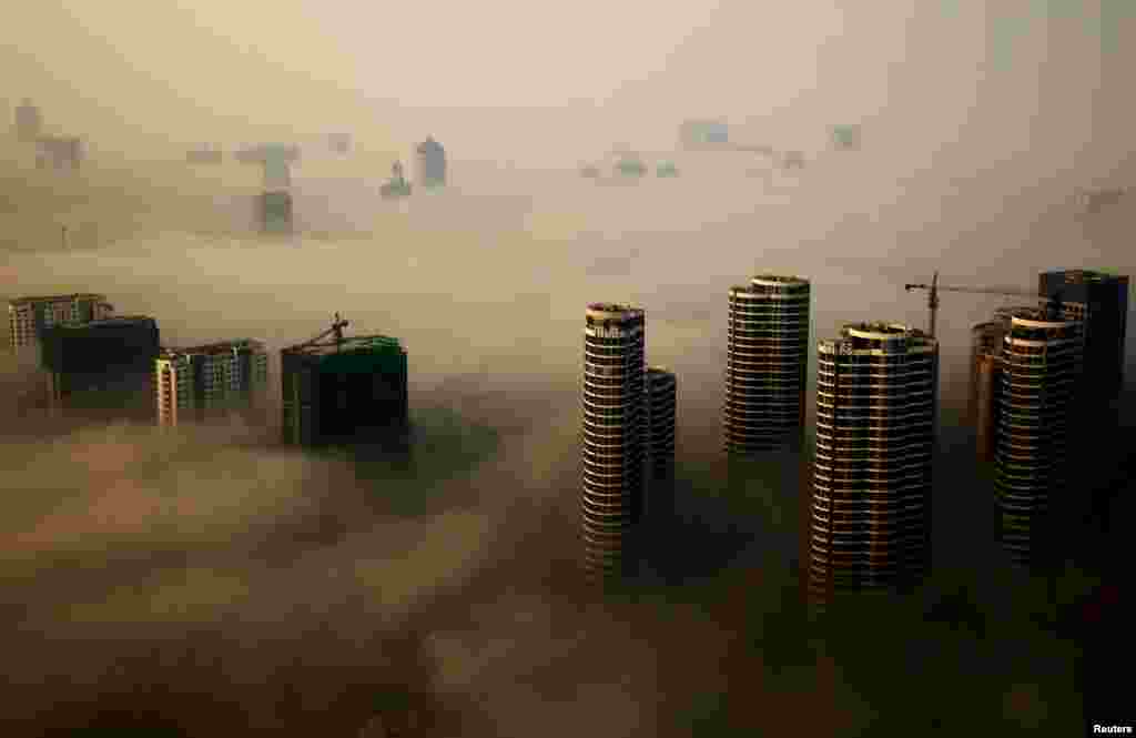 Buildings in construction are seen among mist during a hazy day in Rizhao, Shandong province, China.