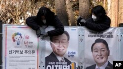 지난 18일 서울에서 한국 선관위 관계자들이 대통령 선거벽보를 게시하고 있다.