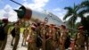 Students gather by an inactive fighter aircraft on display at a Sainik School, or military school, in Goalpara, in the northeastern Indian state of Assam, Aug. 8, 2014.