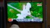 A visitor watches a TV screen showing a news program reporting about North Korea's missile with file footage at a train station in Seoul, South Korea, March 11, 2022