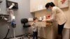 Hudson Diener, 3, tampak mengintip isi lemari sebelum mengikuti uji coba pemberian vaksin COVID-19 Moderna di Commack, New York, pada 30 November 2021. (Foto: AP/Emma H. Tobin)