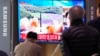 People watch a TV showing a file image of North Korea's missile launch during a news program at the Seoul Railway Station in Seoul, South Korea, March 24, 2022.