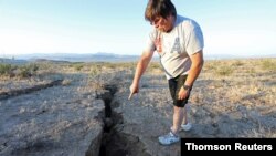 A man looks into a fissure that opened in the desert during a powerful earthquake that struck Southern California, near the city of Ridgecrest, July 5, 2019.