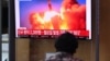 People watch a television news broadcast showing file footage of a North Korean missile test, at a railway station in Seoul on Sept. 28, 2021, after North Korea fired an "unidentified projectile" into the sea off its east coast, according to the South's military.