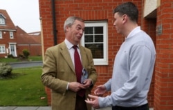 FILE - Leader of the Brexit Party Nigel Farage talks with a supporter during a general election campaign event in Seaham, Britain, Nov. 24, 2019.