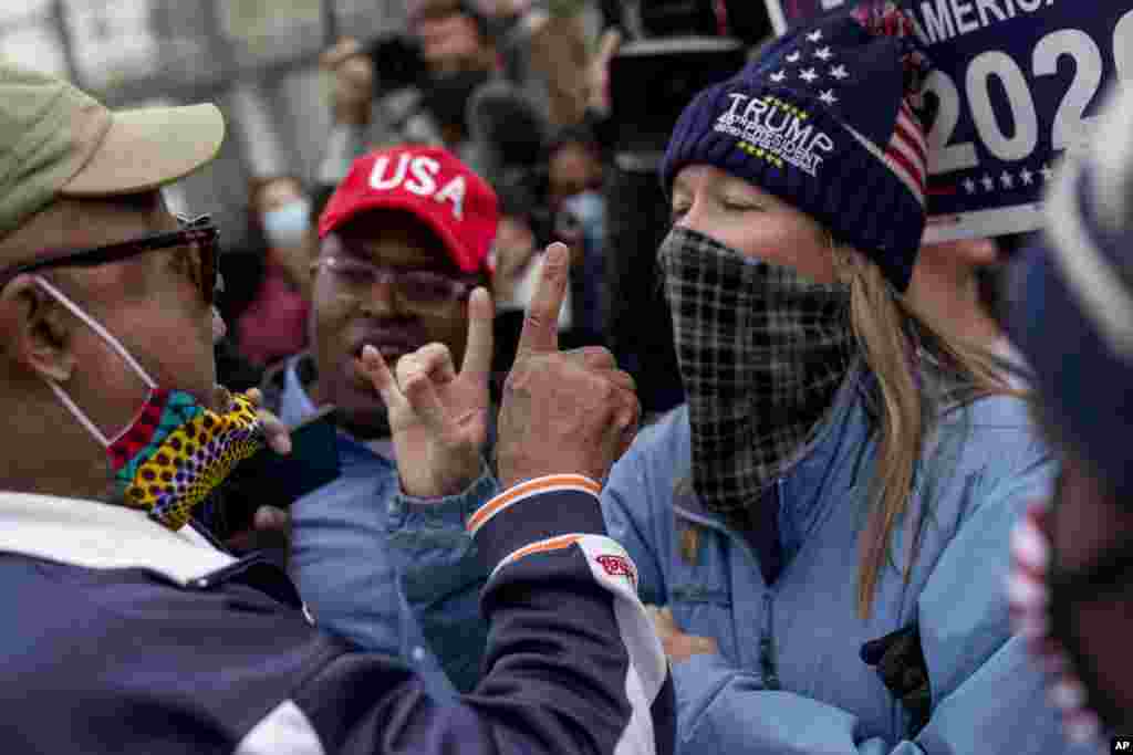 U.S. President Donald Trump&#39;s supporters, right, argues with a counter protester, left, as they protest election results outside the central counting board at the TCF Center in Detroit, Michigan.