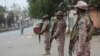 Security personnel stand guard after the government announced to lockdown the city concerns over the spread of the coronavirus, Karachi, Pakistan, March 23, 2020.